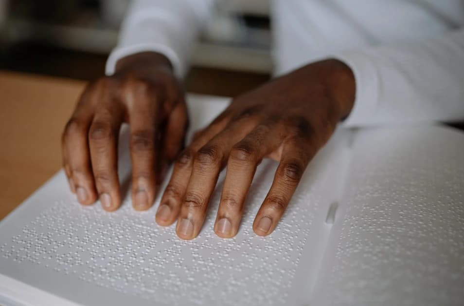 Des mains lisent un document en braille