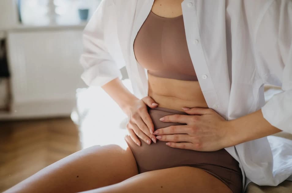 Une femme pose les mains sur son ventre